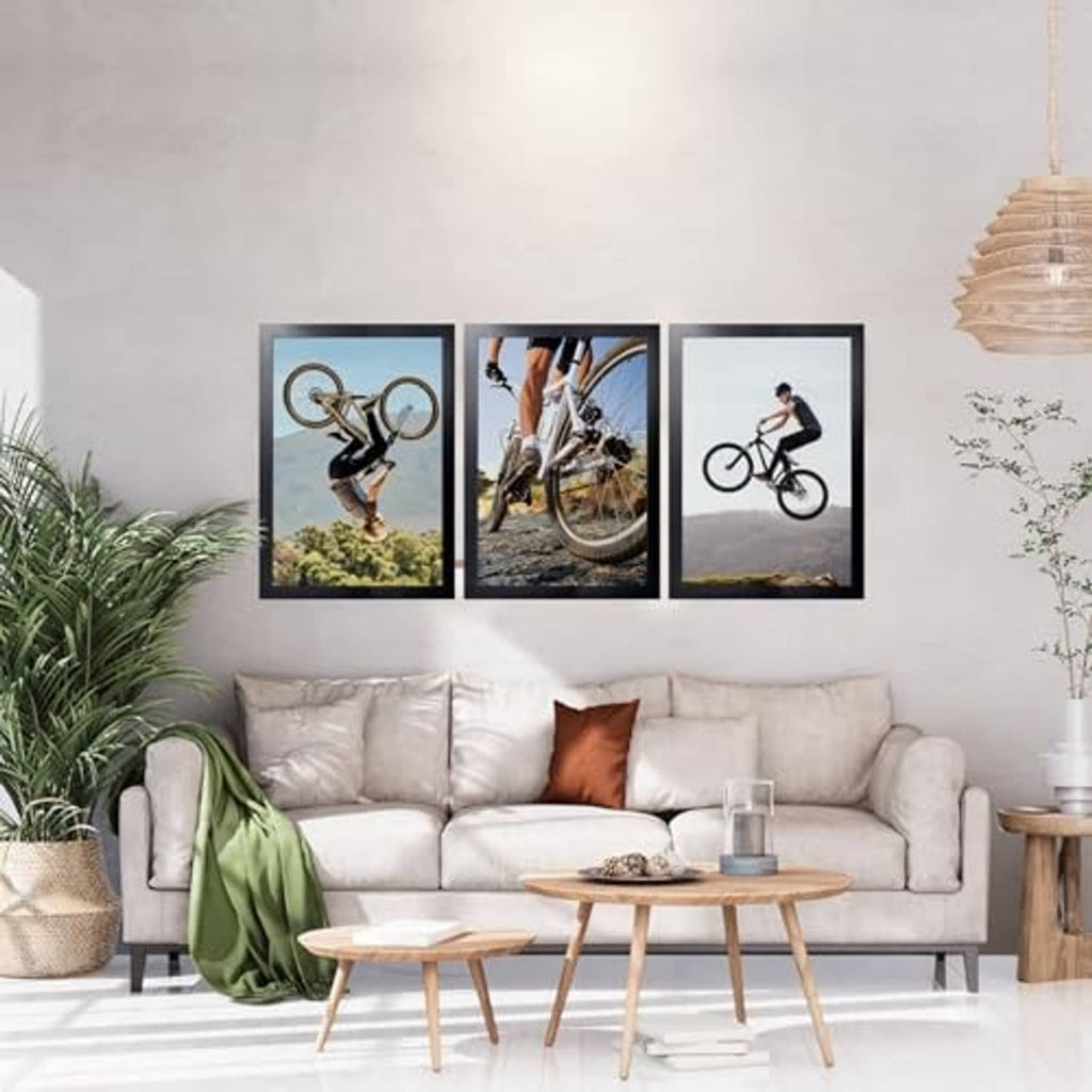 Black picture frame with bike photo on wall among matching frames