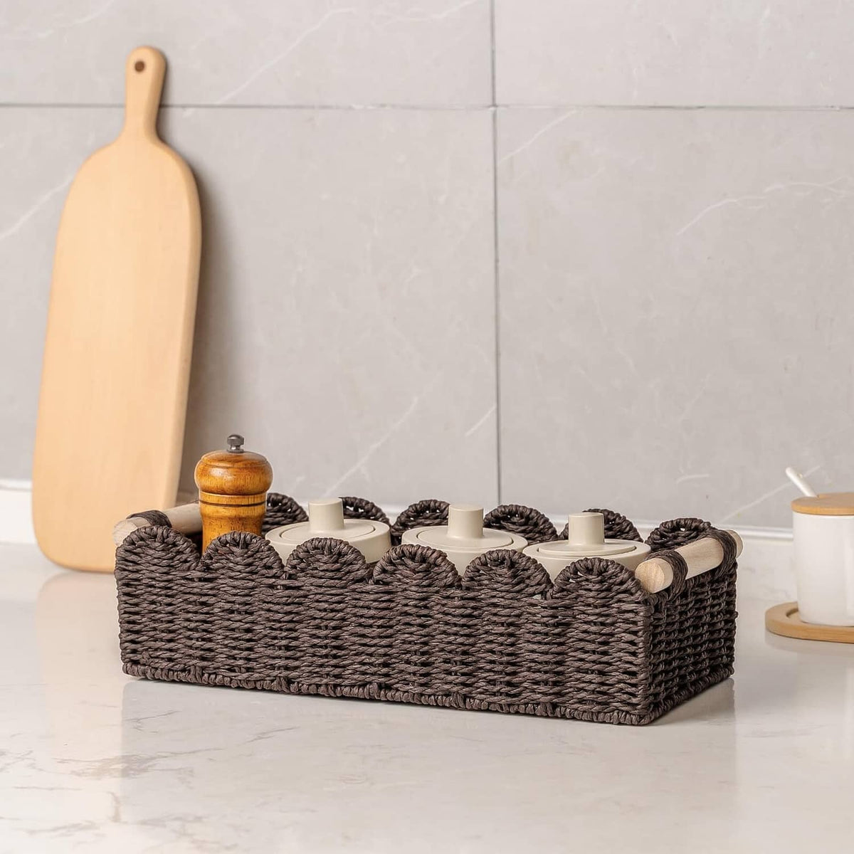 Brown woven toilet paper storage basket with scalloped rim holding multiple rolls