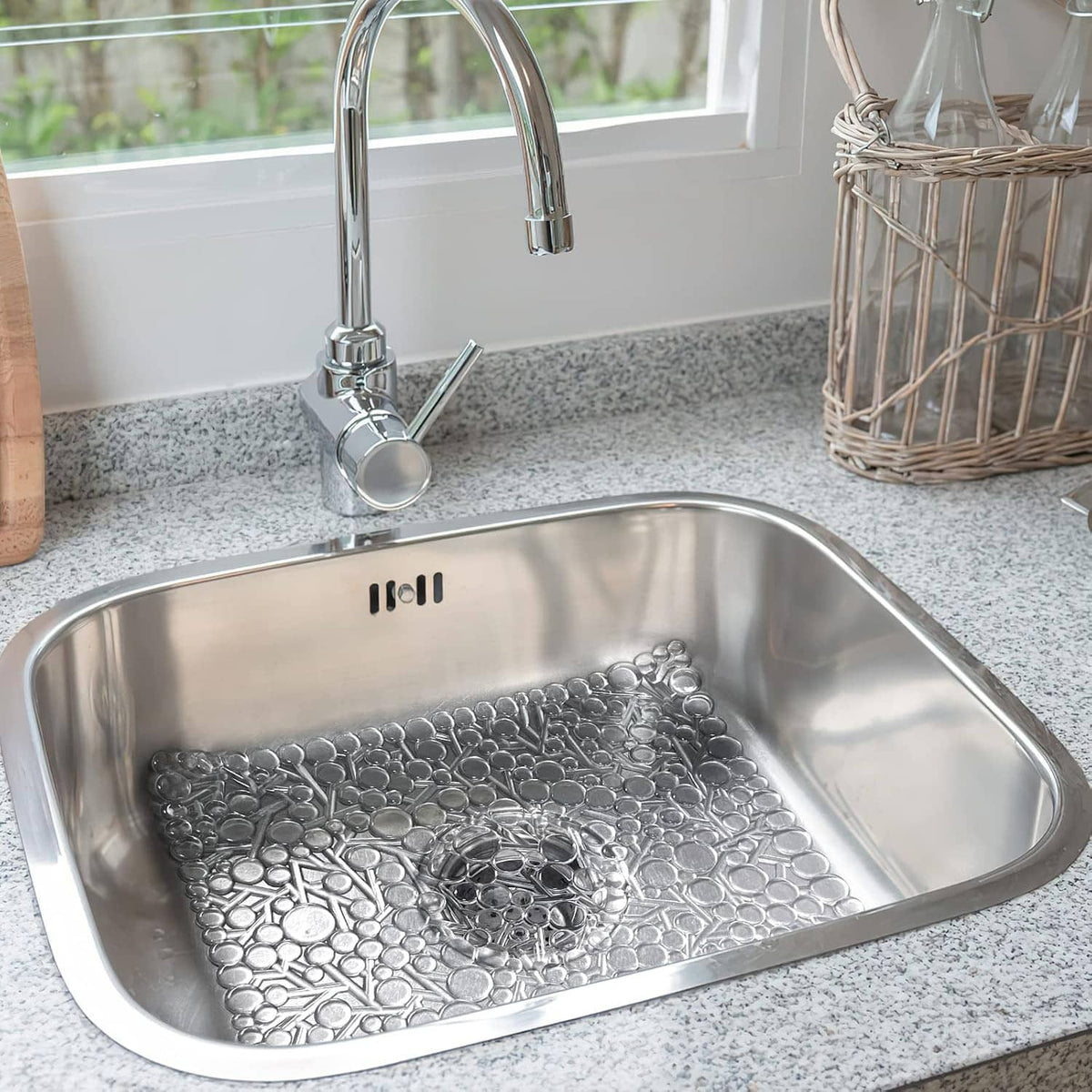 White textured PVC sink mat with raised bubbles inside stainless steel sink
