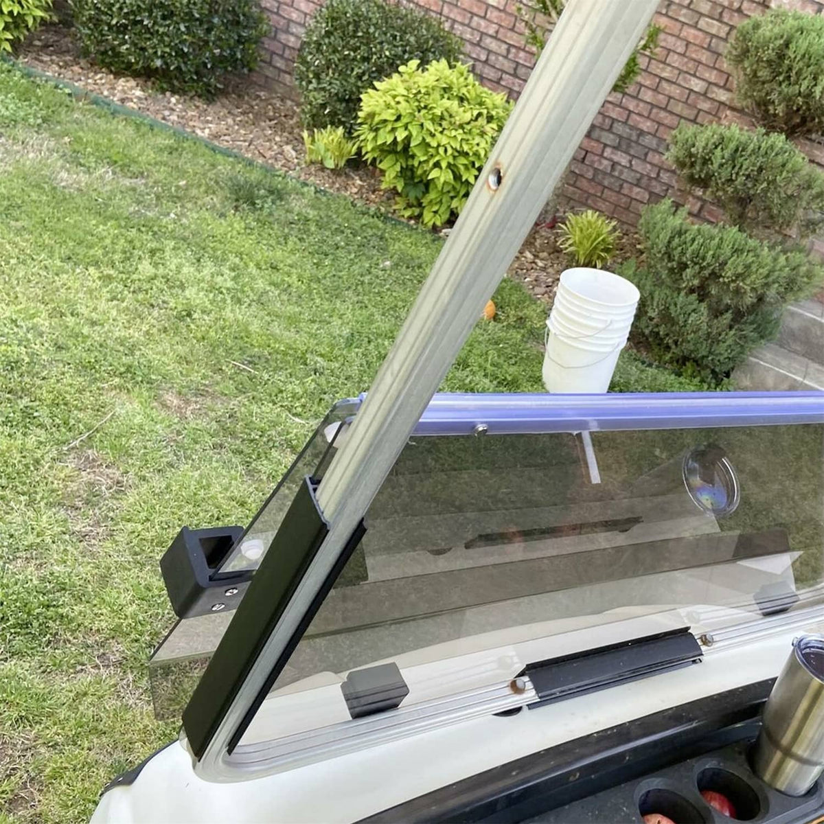 Tinted folding golf cart windshield installed, angled forward with smoky clear glass