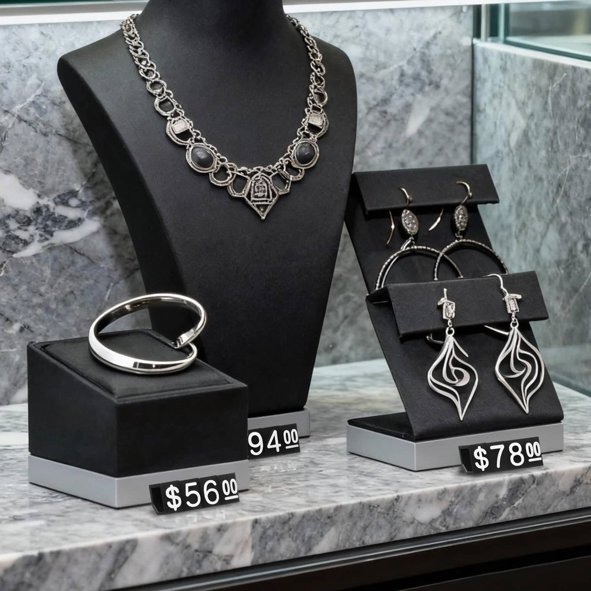 Jewelry display set with price-labeled black cubes showing $56.00 and $94.00
