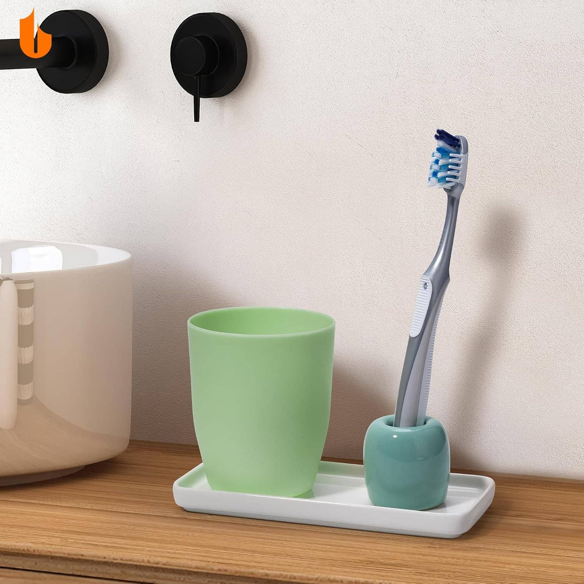 Light green ceramic toothbrush holder on a base tray with an upright toothbrush.