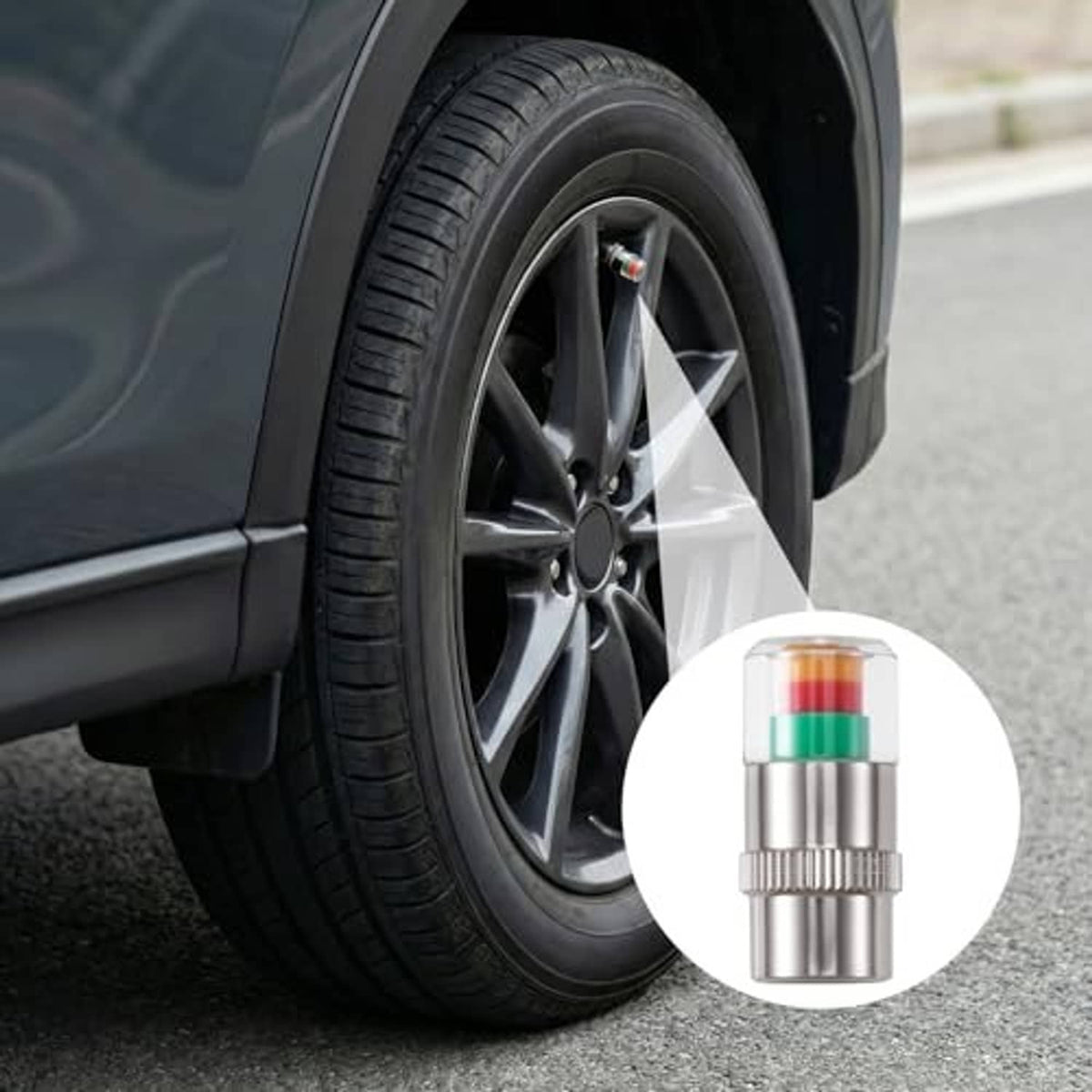 Tire valve cap installed on a black car wheel rim, silver metal with colored bands