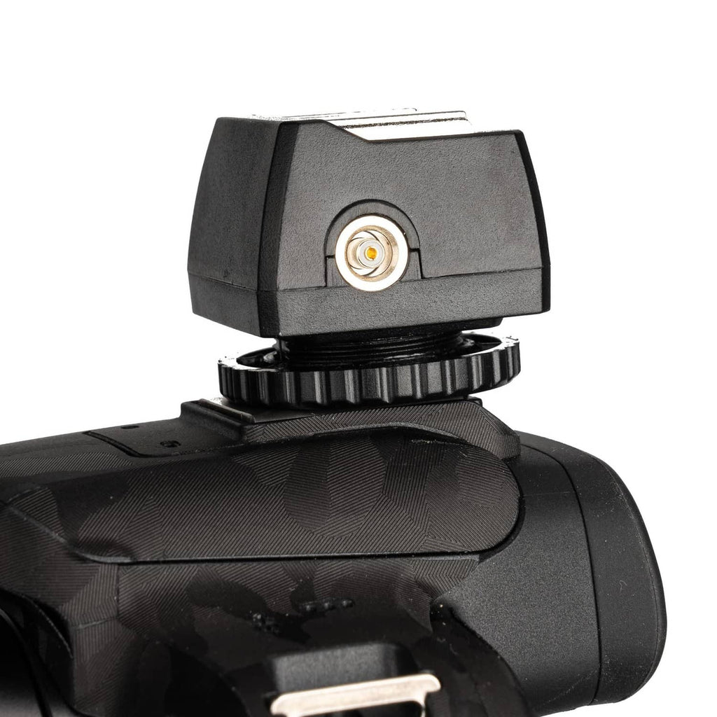 Hot shoe adapter mounted on camera with gold sync port on the side