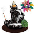 Glossy black ceramic incense burner with cone on top, incense stick, and green lotus base decor
