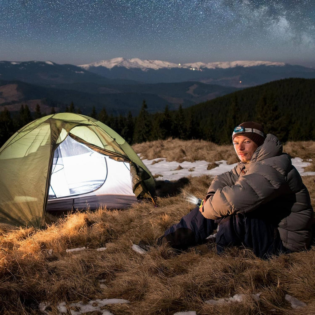 Portable solar hand-crank flashlight; product not clearly visible in this camping scene