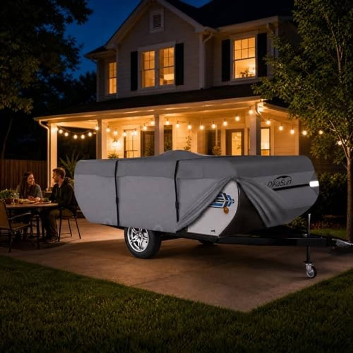 Gray pop-up camper cover over trailer on outdoor driveway with accessory bag