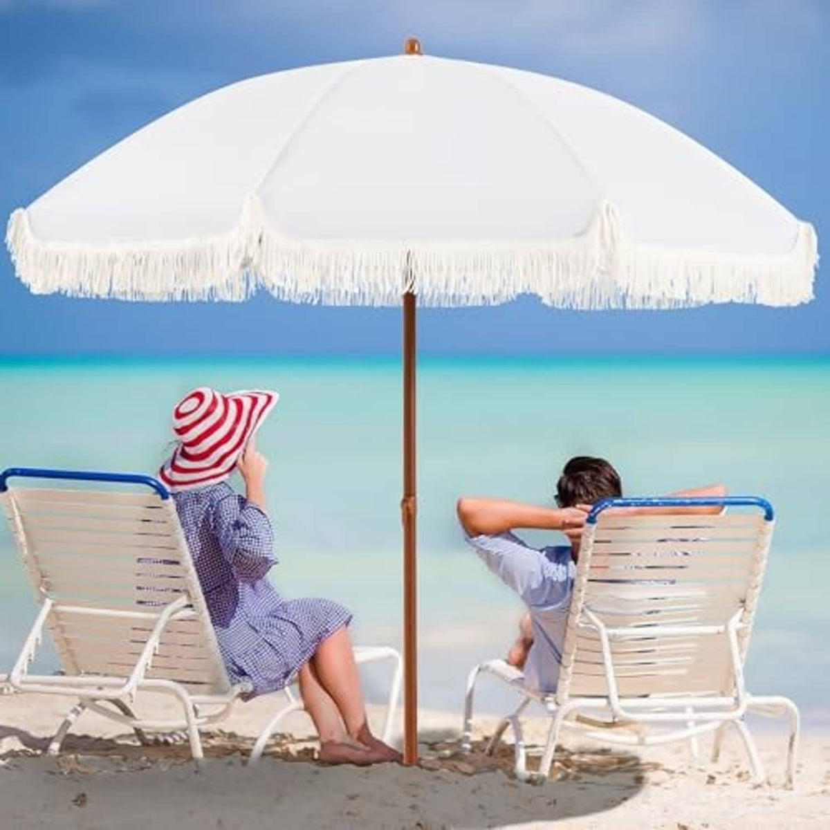 Cream patio umbrella fully opened with white fringe edge and wooden pole