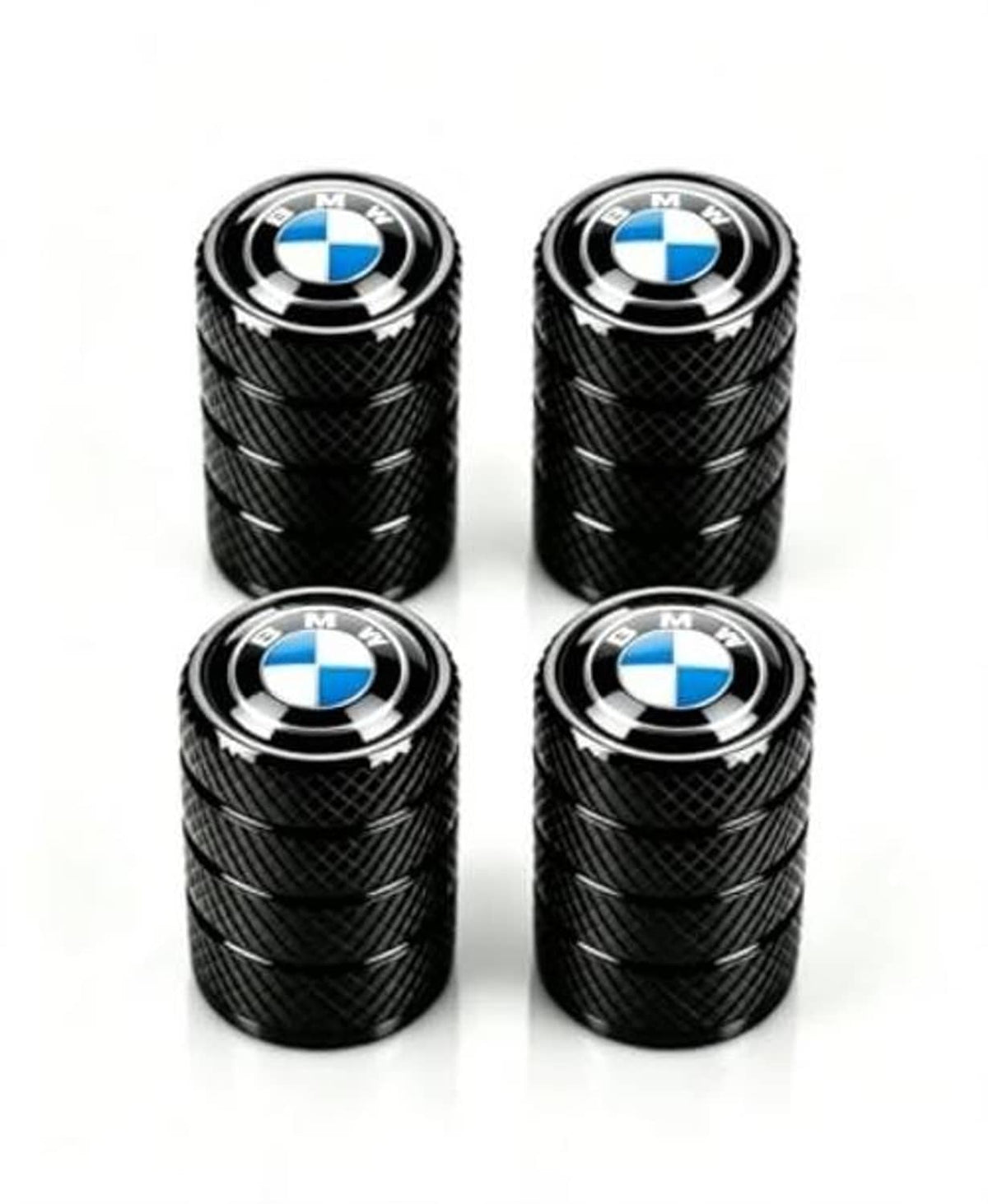 Four black tire valve stem caps with textured grip and BMW blue-and-white emblem
