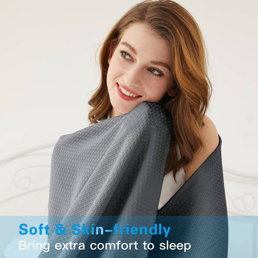 Dark gray cooling blanket with subtle textured weave, held near the shoulder