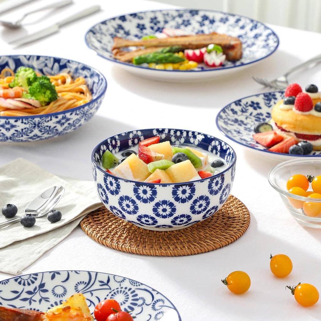 Blue and white patterned bowls close-up with pasta, fruit, and salad