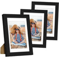 Set of 3 black picture frames with white mats and photo inserts, overlapping front views