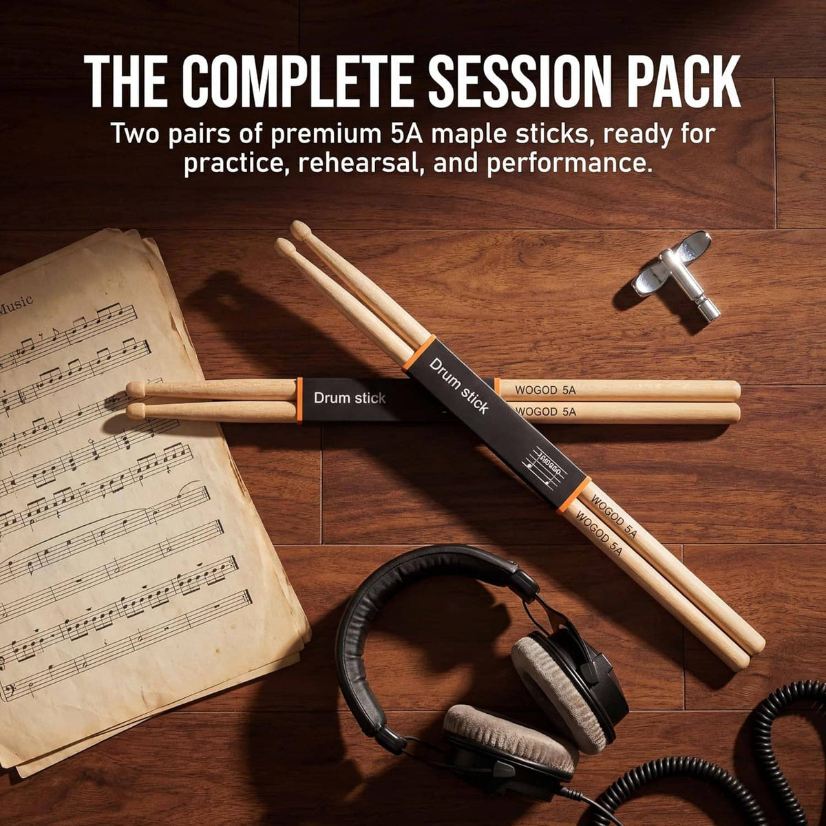 Two pairs of 5A maple drumsticks on a wooden surface with accessories nearby