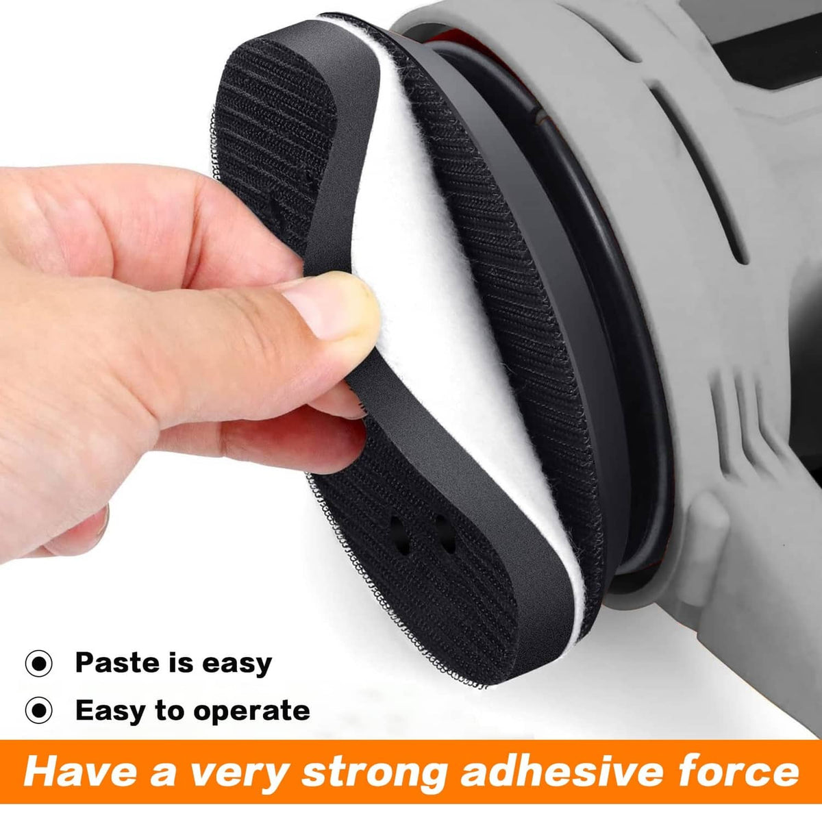 Hand holding black and white hook-and-loop sanding interface foam pad