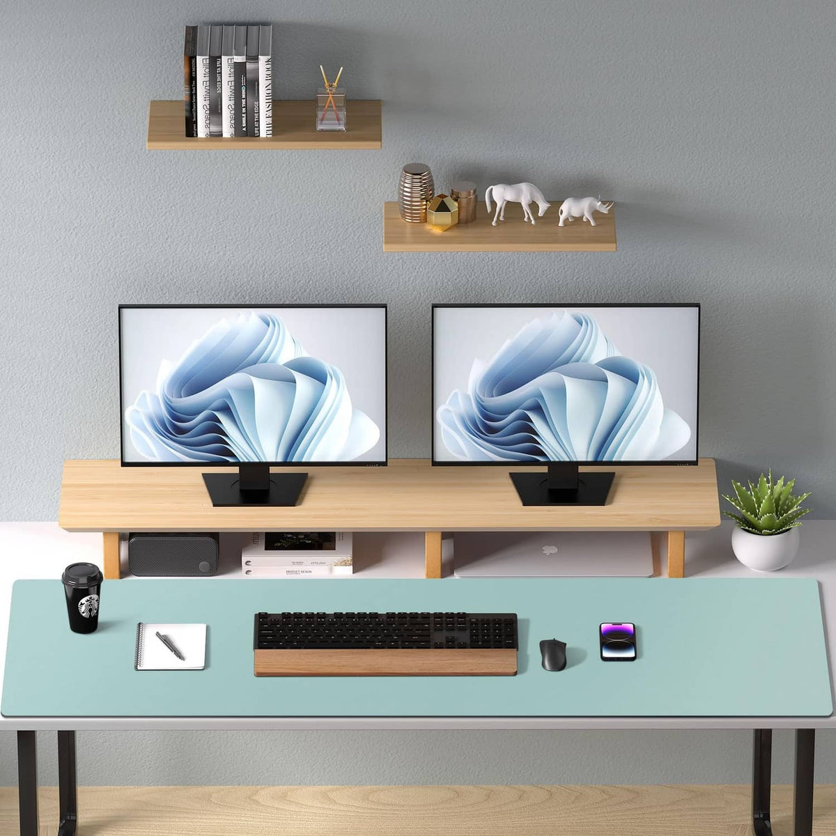 Light blue desk pad laid flat beneath two monitors and office keyboard