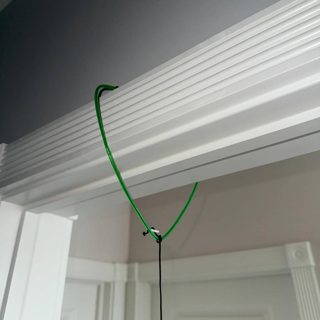 Green hanging loop attached to a ceiling support for a cat toy