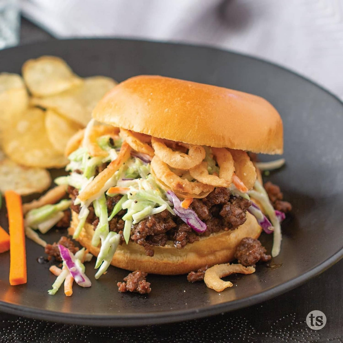 Sandwich burger with dark Bayou Bourbon glaze drizzled over the patty and slaw