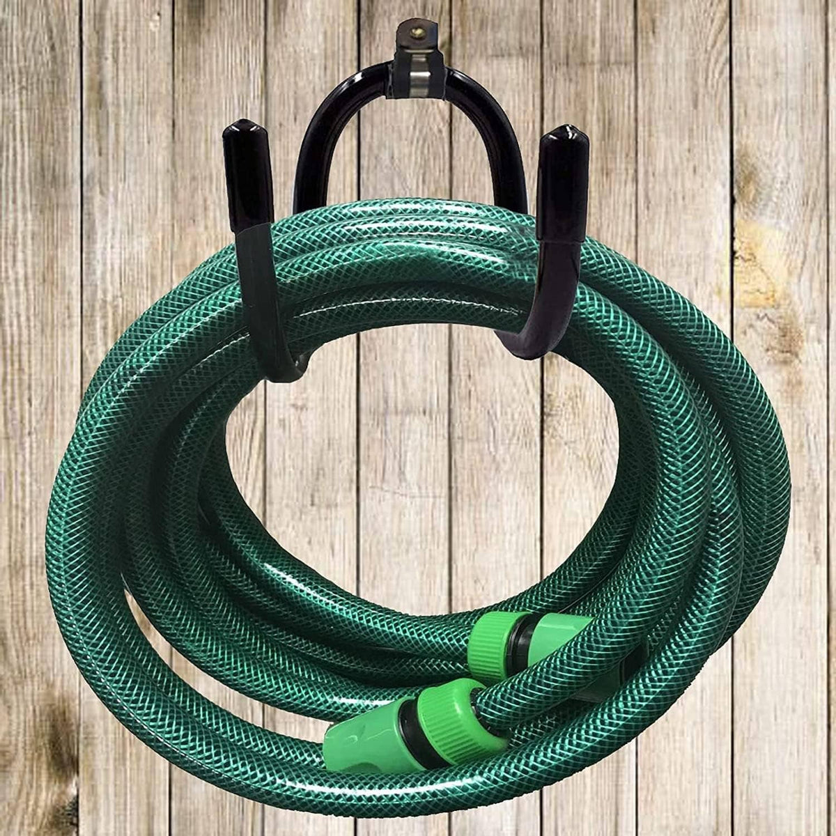 Black hose hanger with four posts holding dark teal garden hose coil
