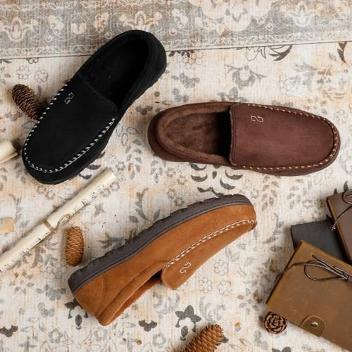 Moccasin house slippers in black, brown, and tan with contrast stitched trim