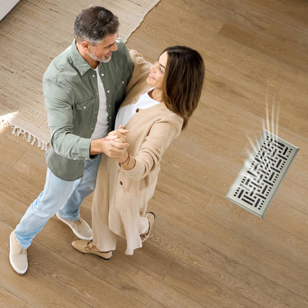 Floor register vent on wood floor near people, showing grille pattern and frame