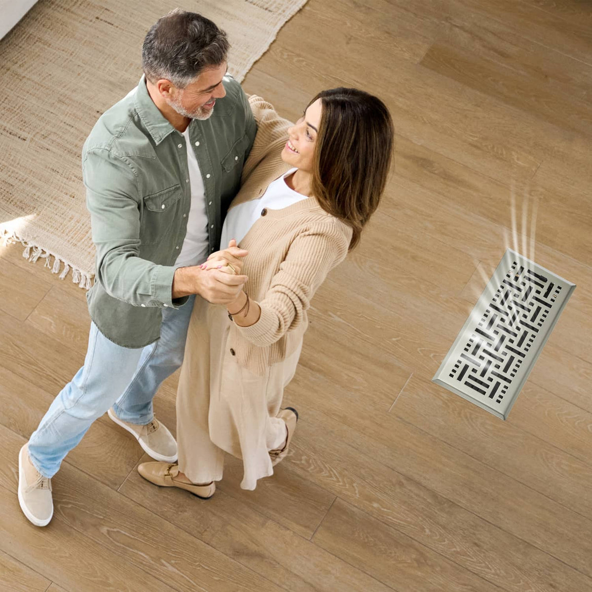 Floor register vent on wood floor near people, showing grille pattern and frame
