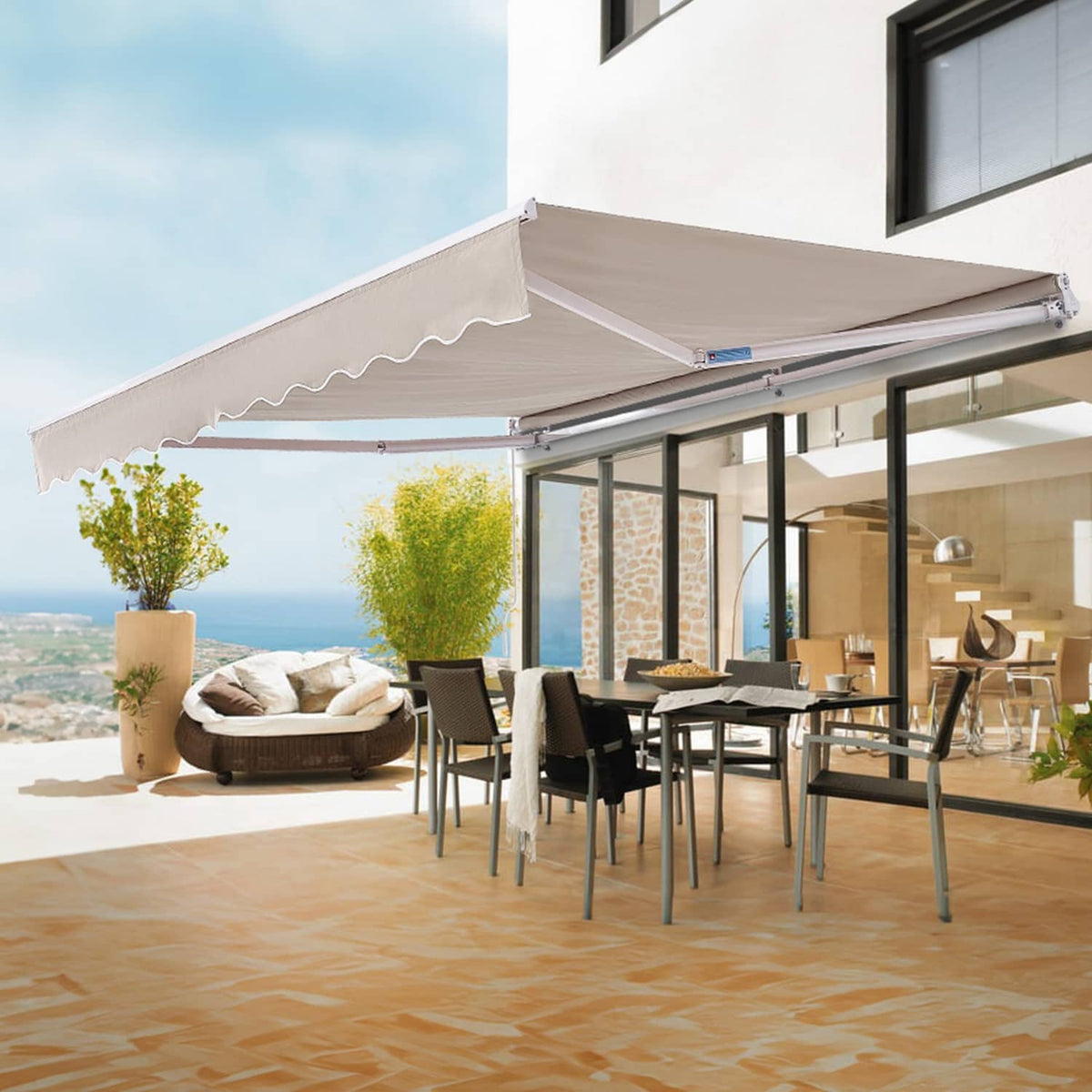 Retractable patio awning mounted under a roof with beige canopy and scalloped edge