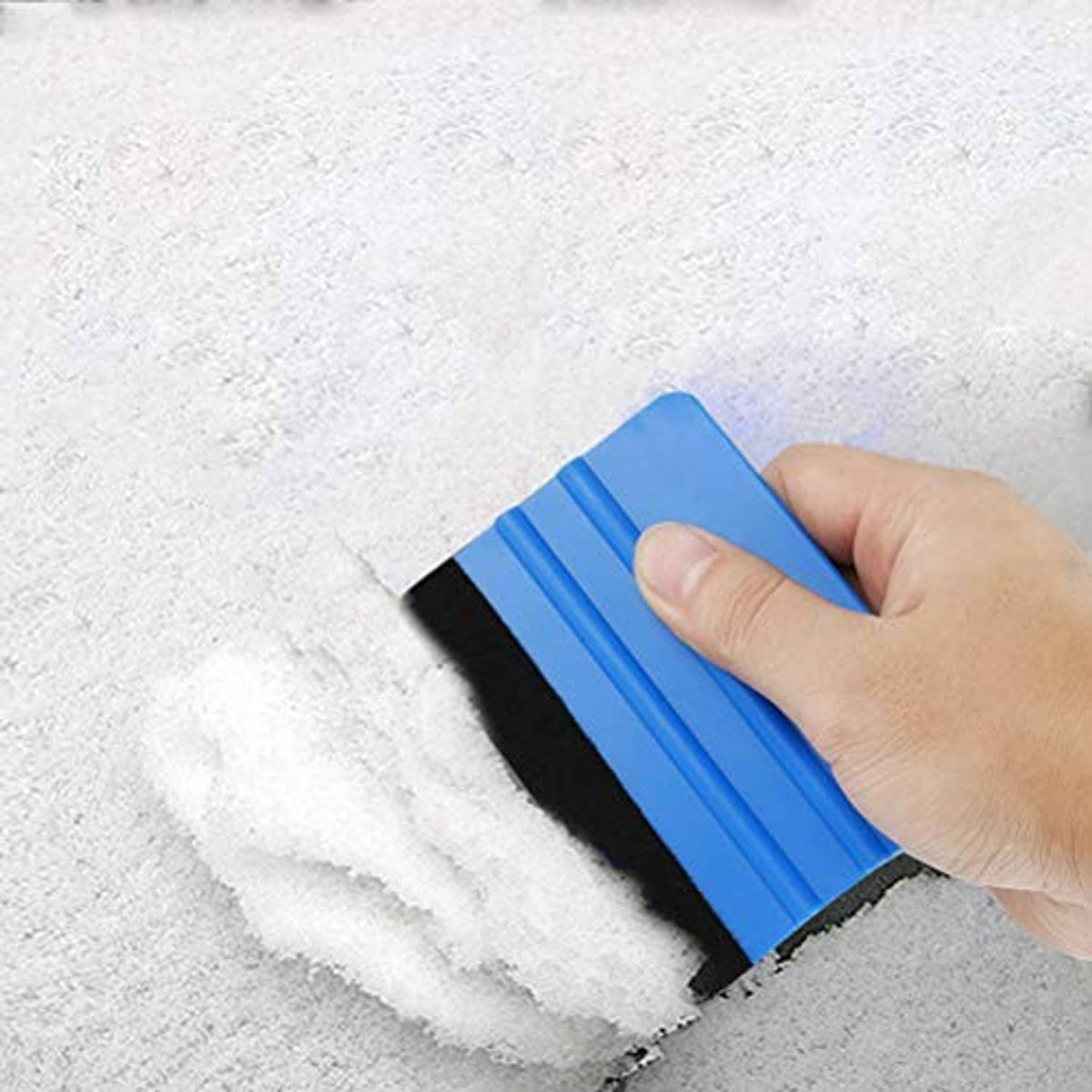 Blue felt edge squeegee with black edge, hand smoothing over a concrete surface