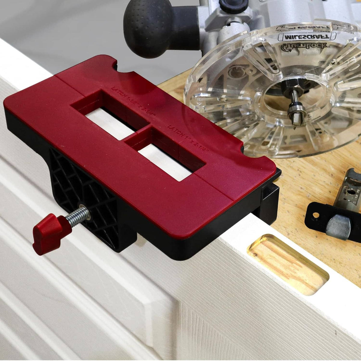 Red hinge jig with black base and adjustment knob holding a hinge plate