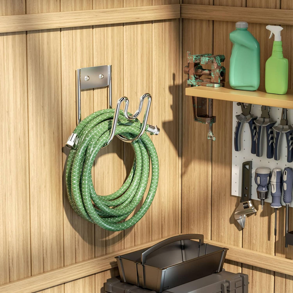 Silver hose holder on a wooden wall with a coiled green garden hose