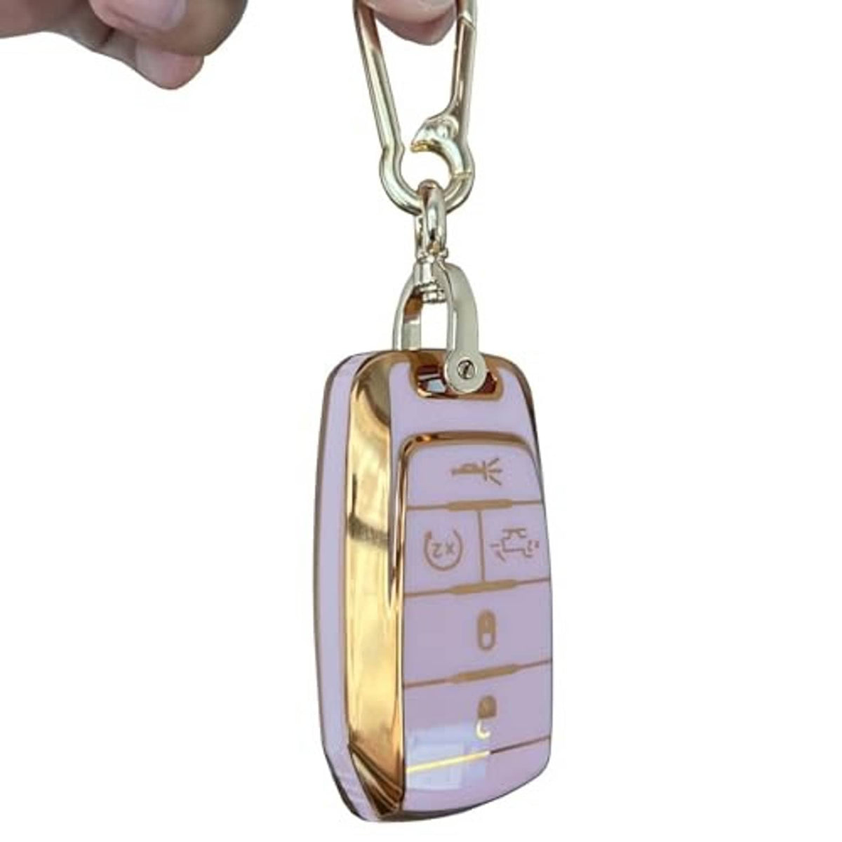 Pink key fob cover with gold trim and keyring, held by a hand