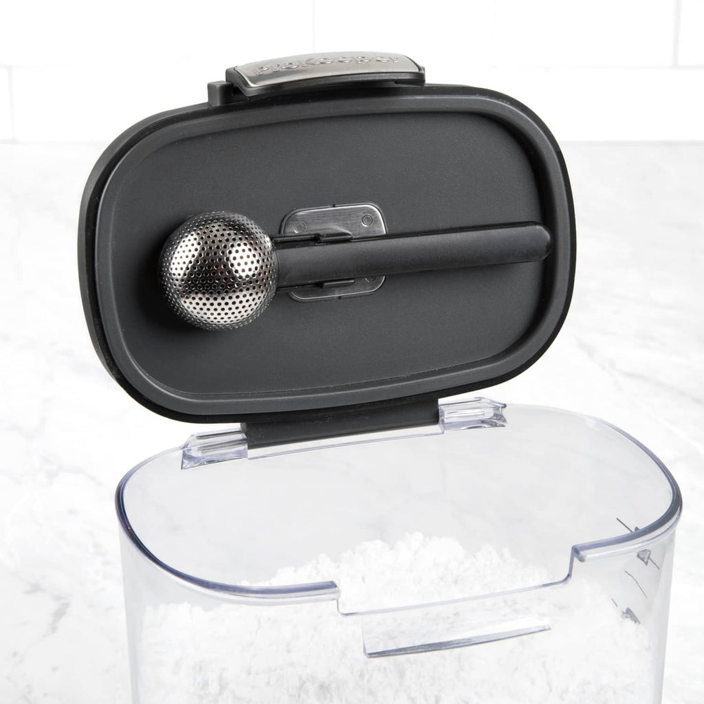 Clear airtight food storage container with black lid and perforated metal scoop insert