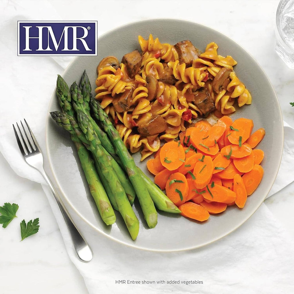 Plate of beef stroganoff noodles with asparagus and carrot slices