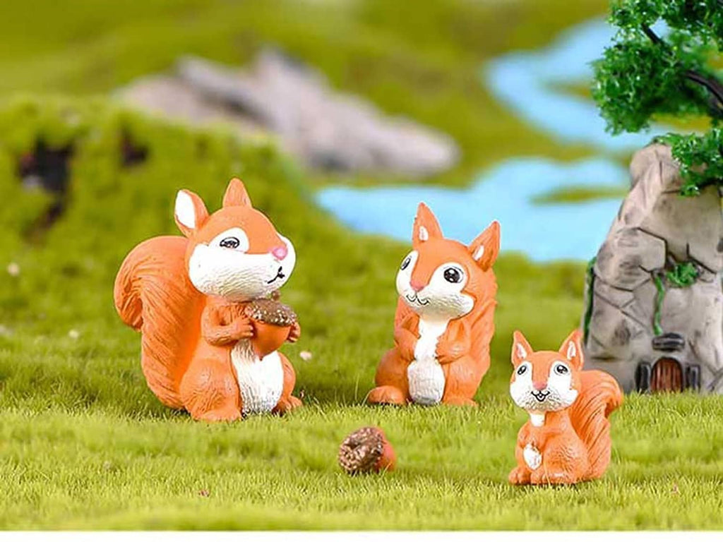 Miniature squirrel figurines, orange and white, with three standing on green grass
