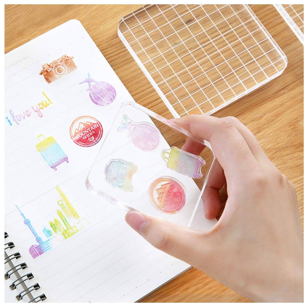 Clear acrylic stamp block with grid, hand holding block over stamped artwork