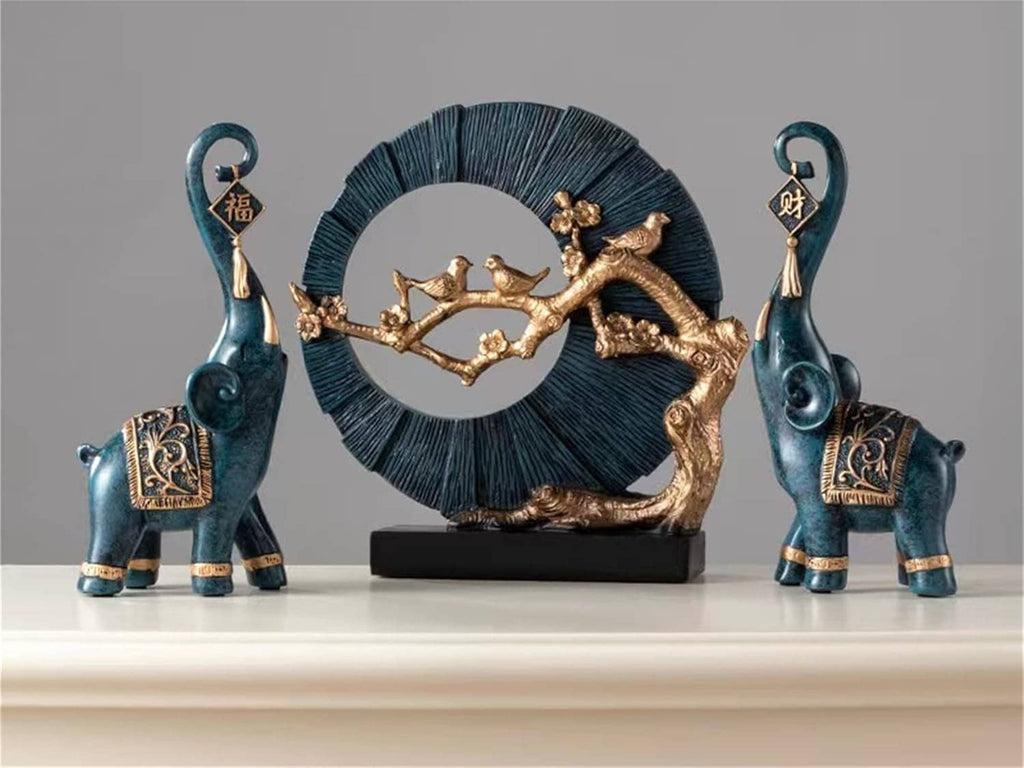 Two blue elephant luck statues beside a decorative gold circular ornament on a base