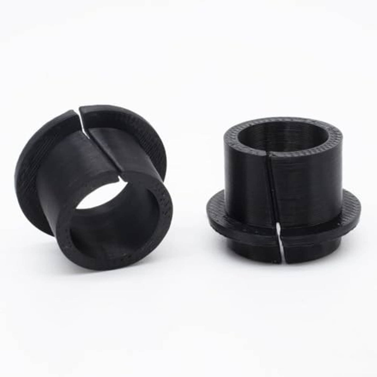 Manual transmission shift cable bushing kit, two black cylindrical rubber bushings