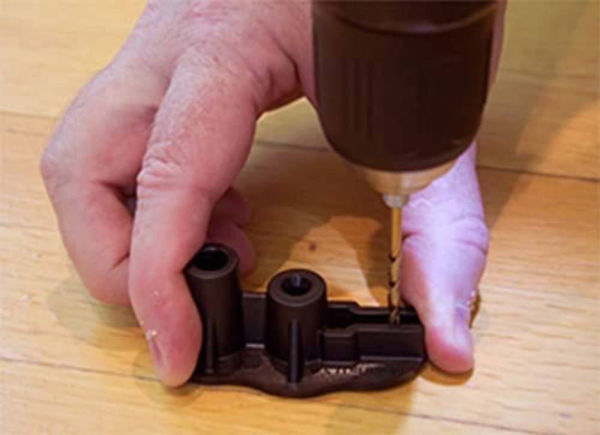 Snap base being screwed into hardwood floor using an electric drill bit