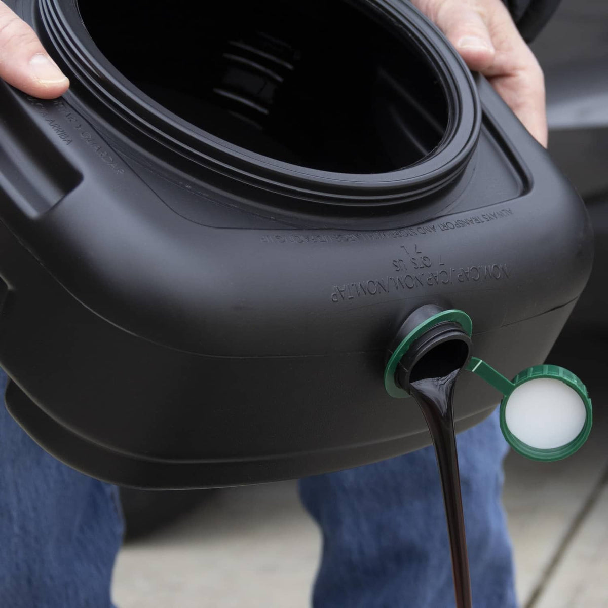 Black oil drain pan with lid, green spout cap, and attached hose