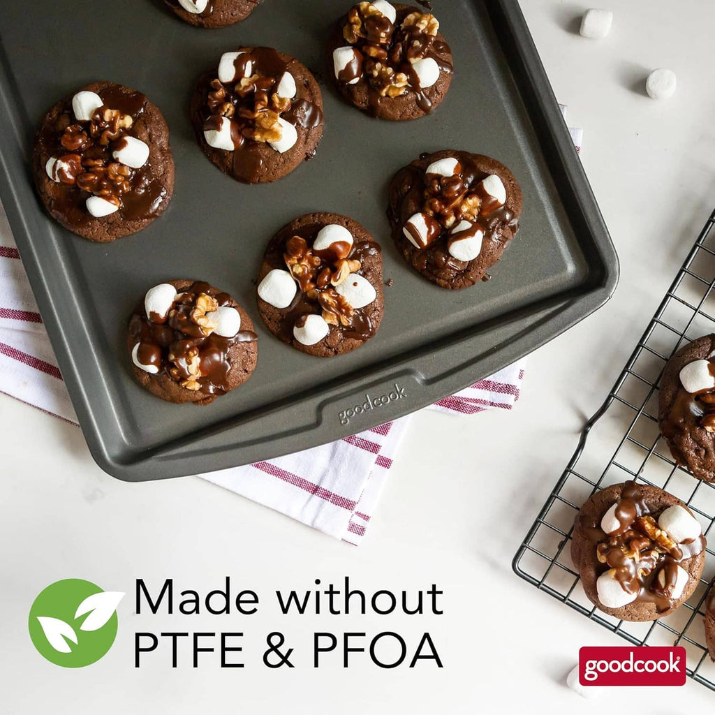Gray nonstick baking sheet with chocolate cookies topped with white pieces