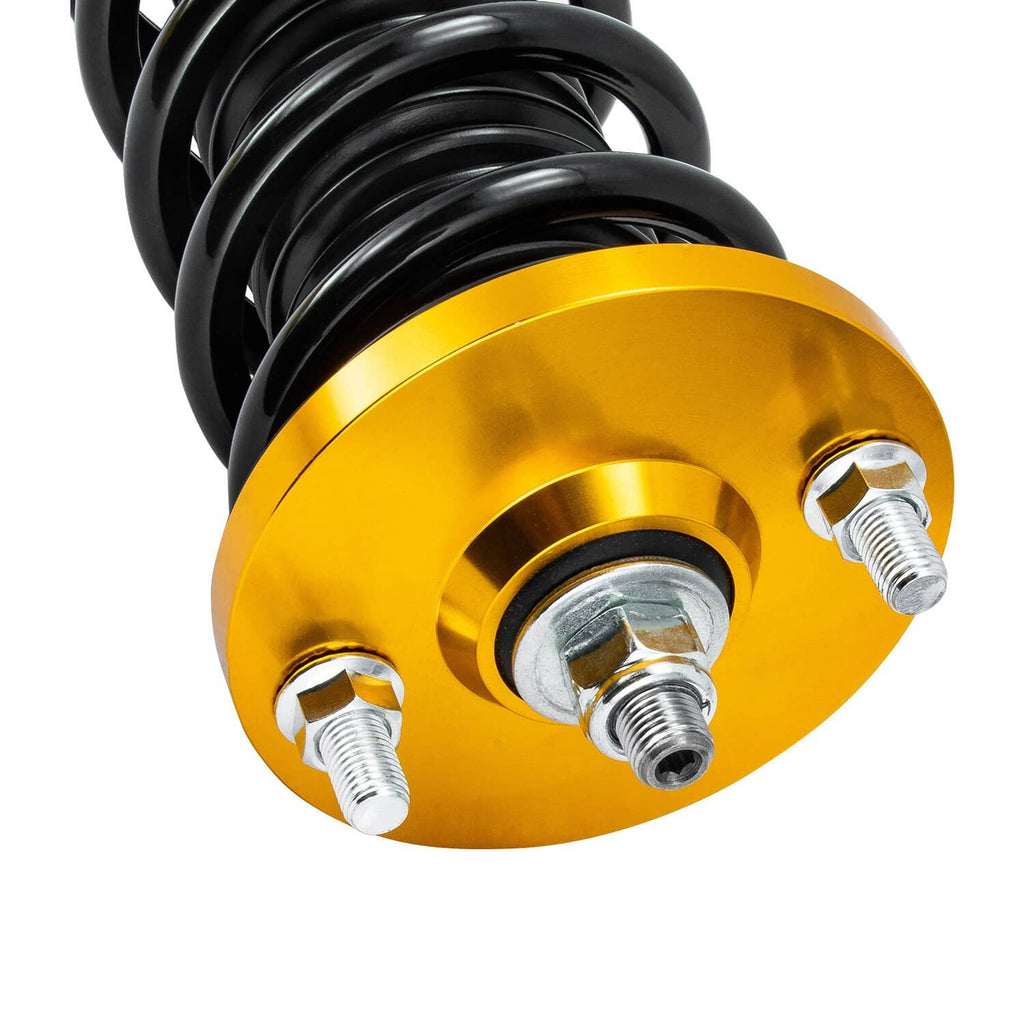 Close-up coilover top mount with gold housing, black spring, and threaded stud hardware