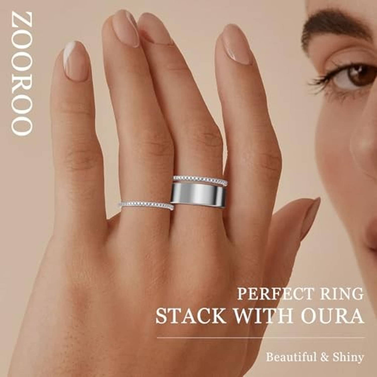 Oura stacking rings, one thin beaded band and one wide silver band on a hand
