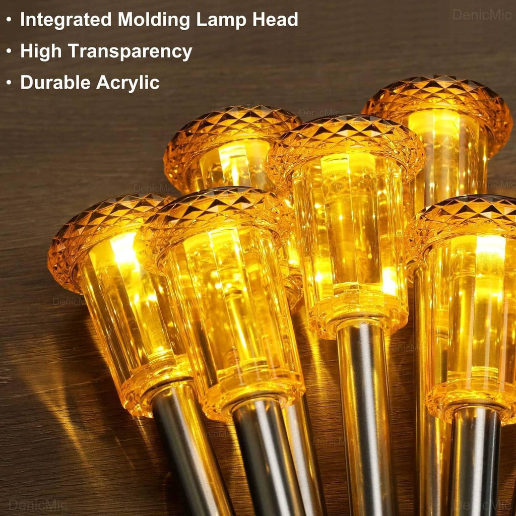 Close-up of multiple amber transparent lamp heads on shiny metal spike poles