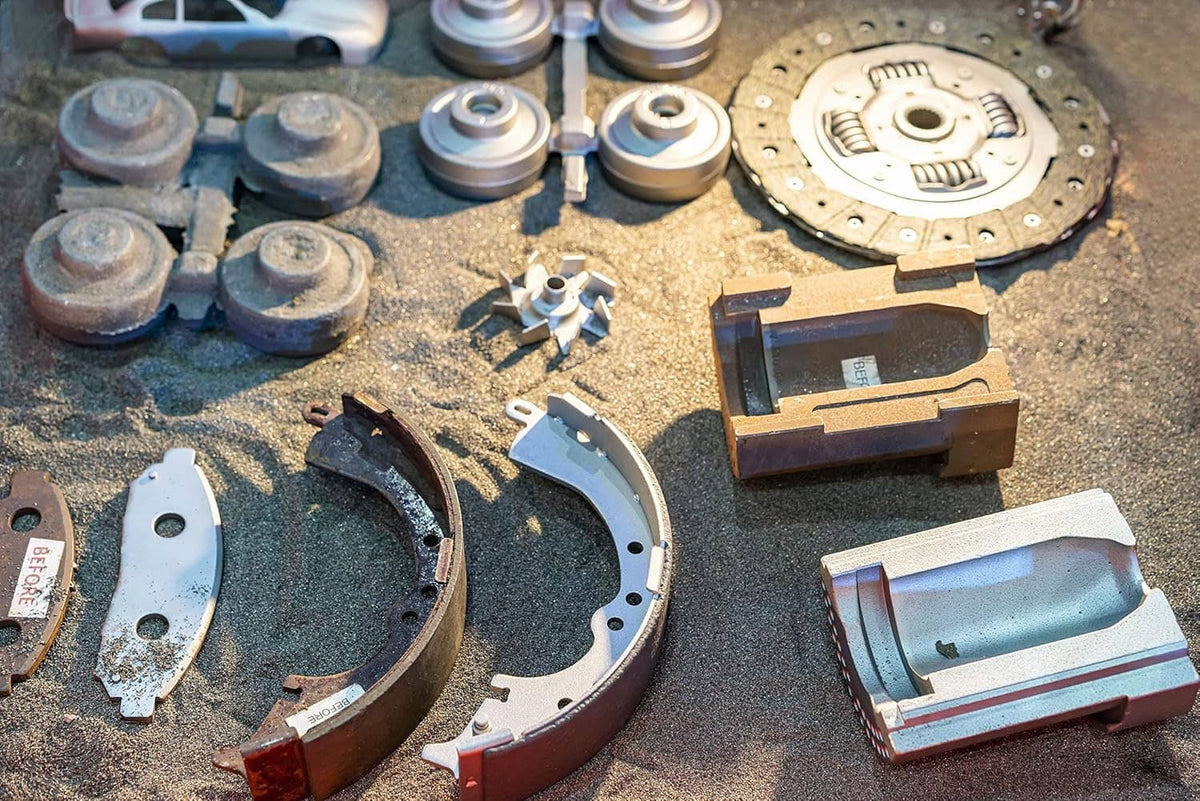 Automotive brake and clutch parts with abrasive residue on a workbench