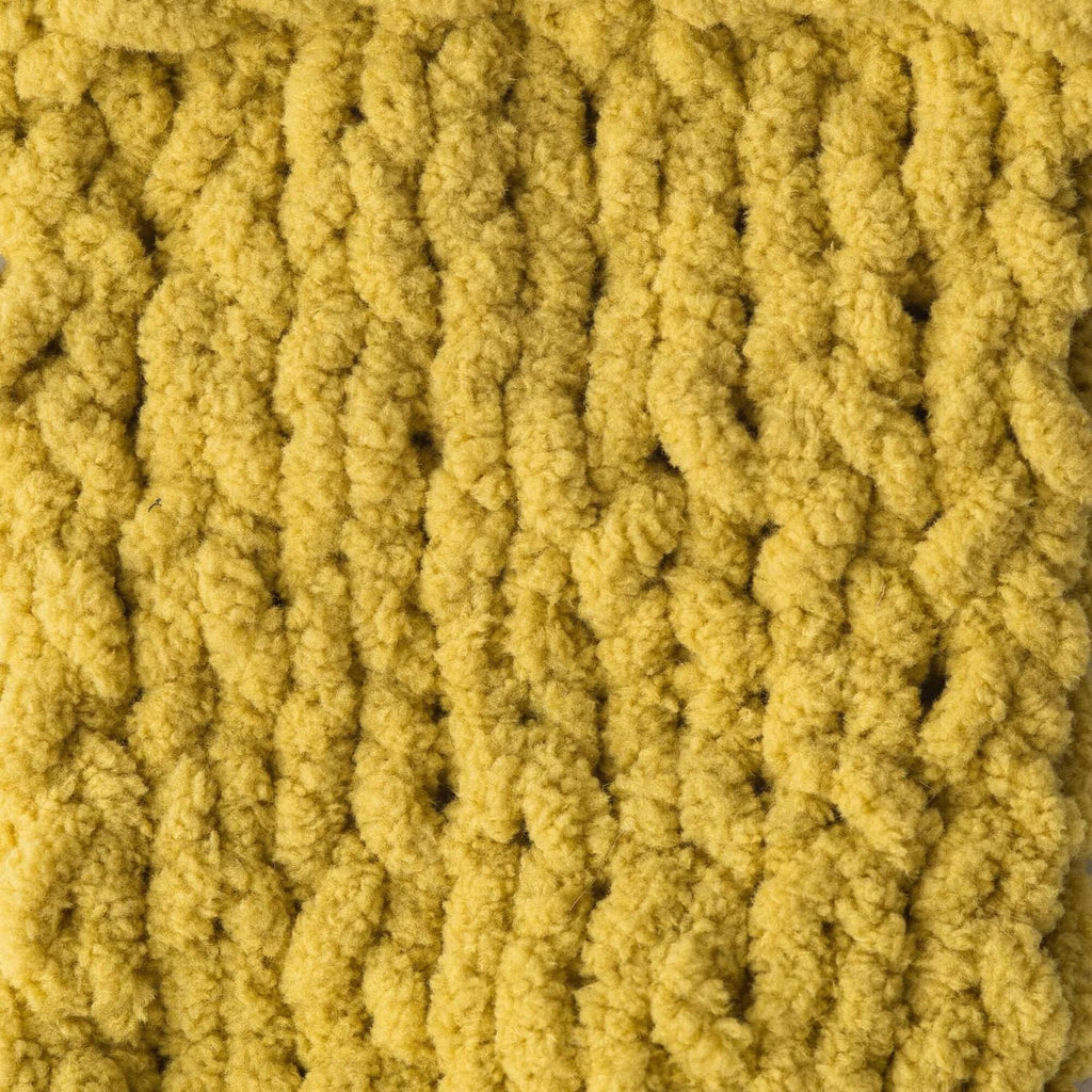 Yellow super bulky chenille yarn with dense loop texture, close-up view.