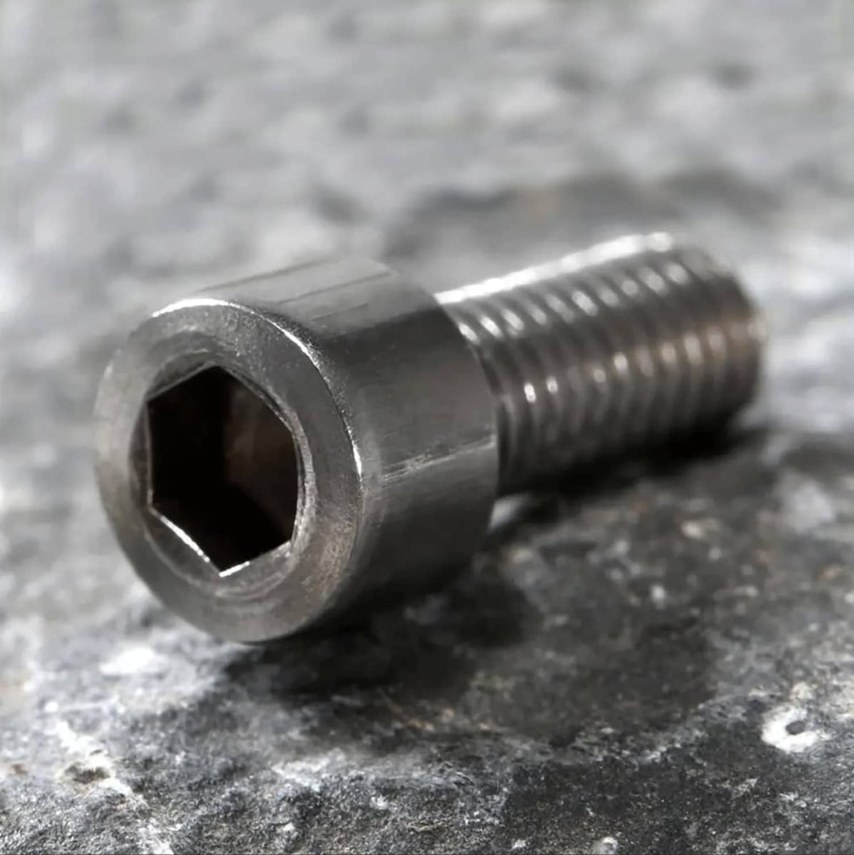 Close-up of silver hex socket cap bolt head and threaded shaft