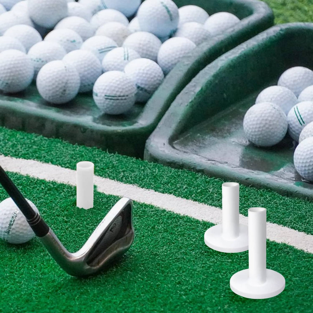 White rubber golf tees standing on a green practice mat with golf balls nearby