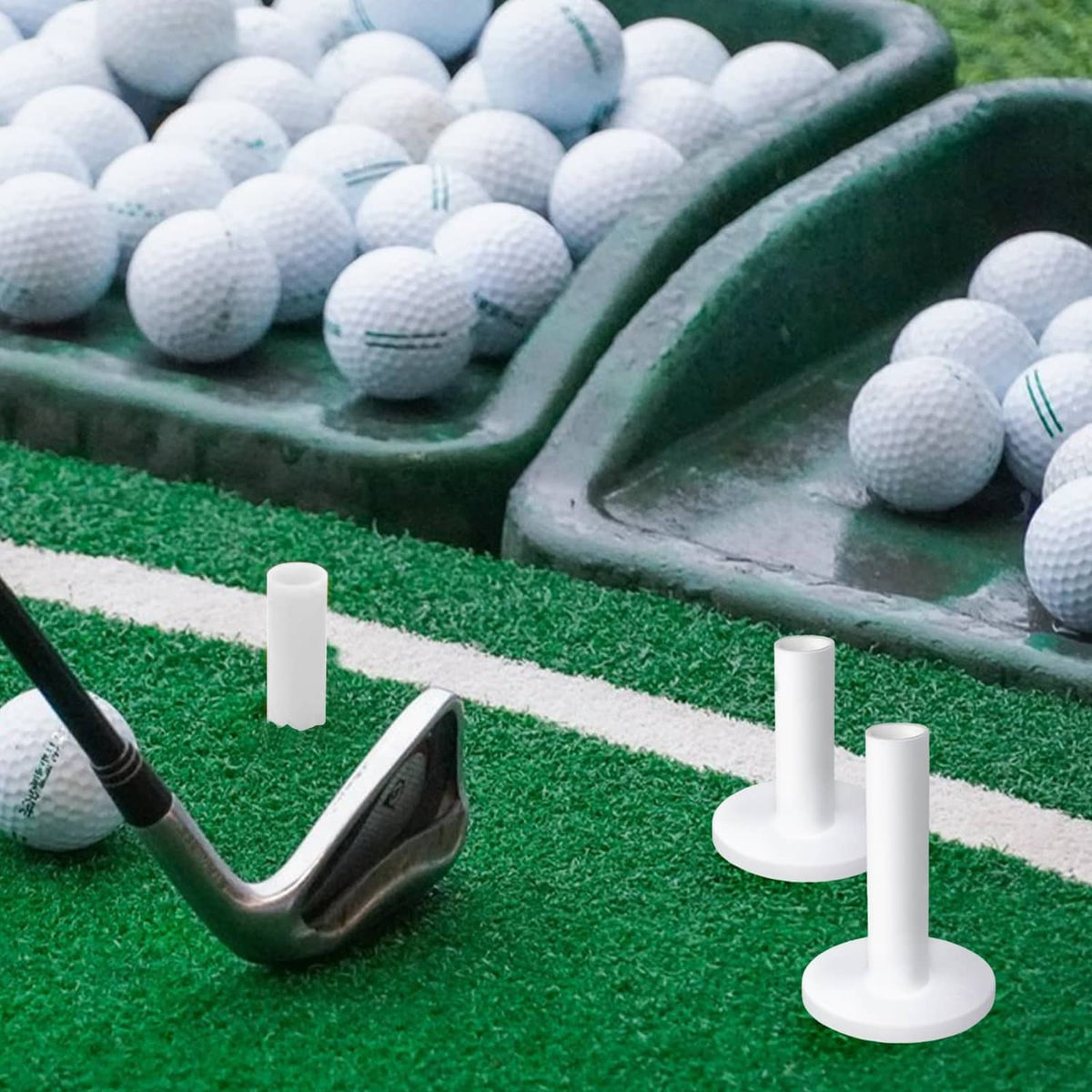 White rubber golf tees standing on a green practice mat with golf balls nearby
