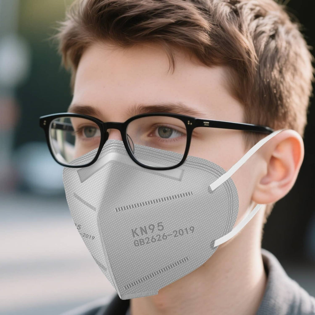 Person wearing a grey KN95 respirator face mask with ear loops and molded nose strip.