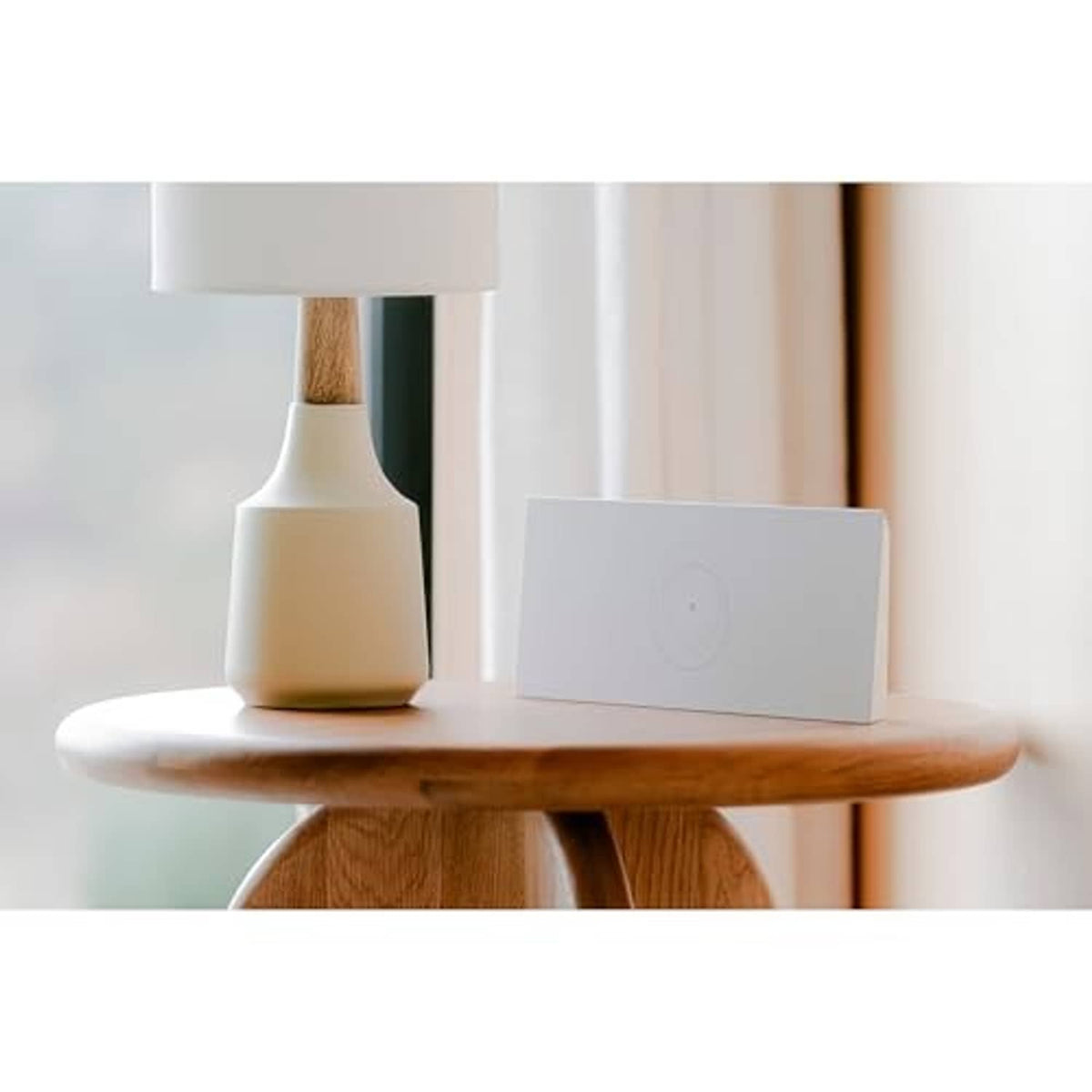 White Wi‑Fi router with circular logo on a shelf