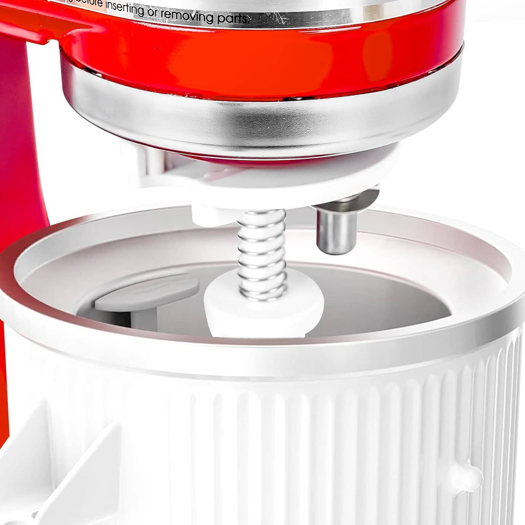 Ice cream maker mixing paddle and spring over white frozen bowl insert